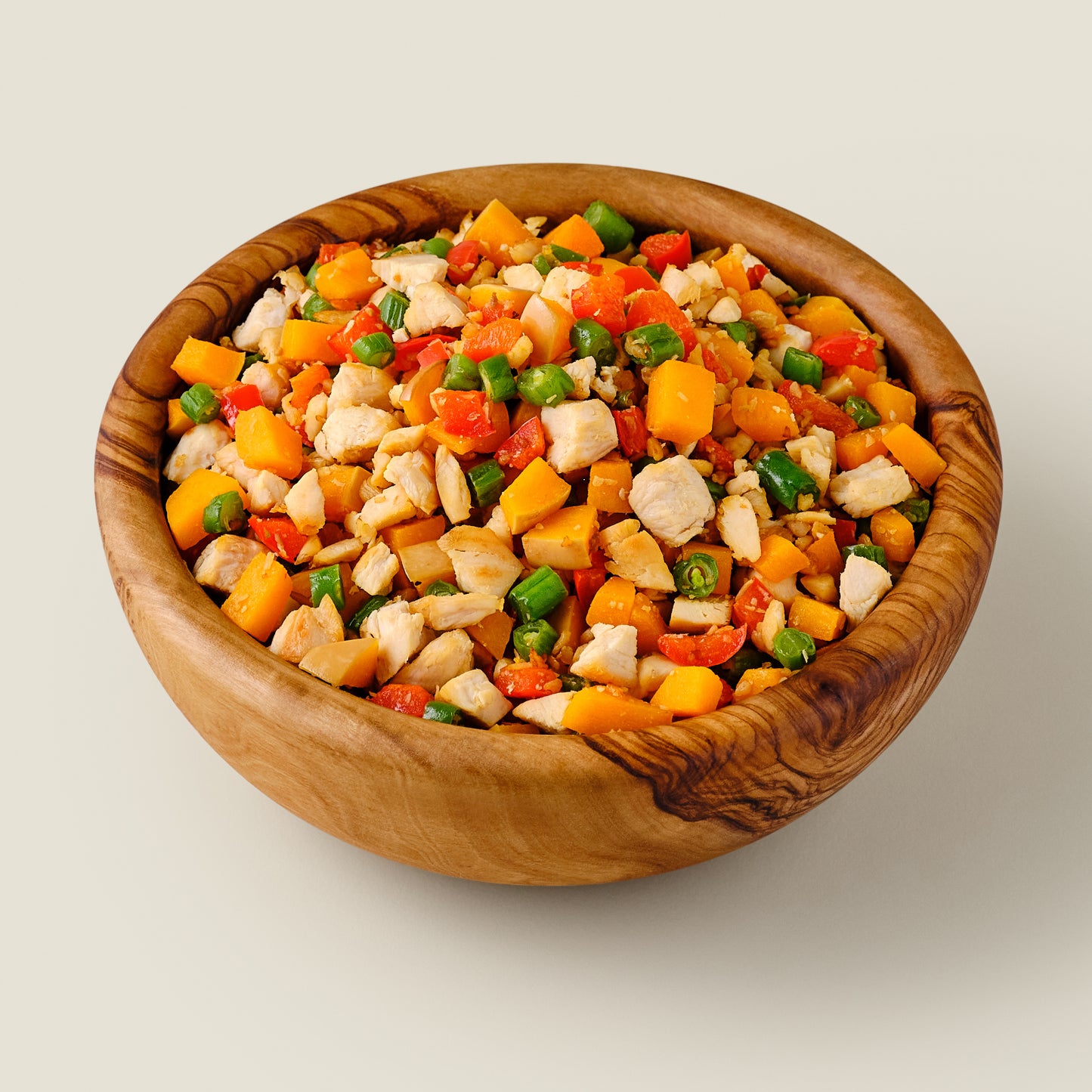 Organic grain-free chicken dog food in a rustic wooden bowl, made with high-quality organic fresh ingredients for a healthy, balanced diet.